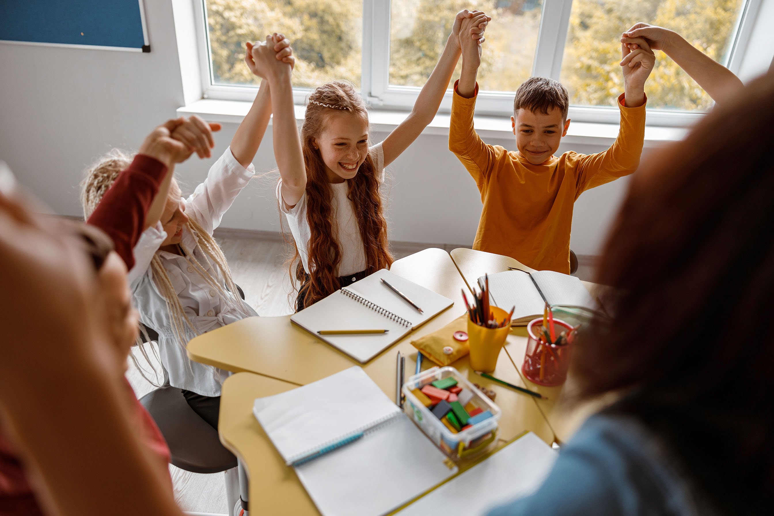 schoolchildren-sitting-at-the-table-and-raising-th-2023-11-27-05-35-54-utc